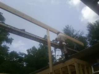 Carpenter setting a ridge beam over a new addition frame — Ice Dam Removal by Roofing Brothers in Gold Bar