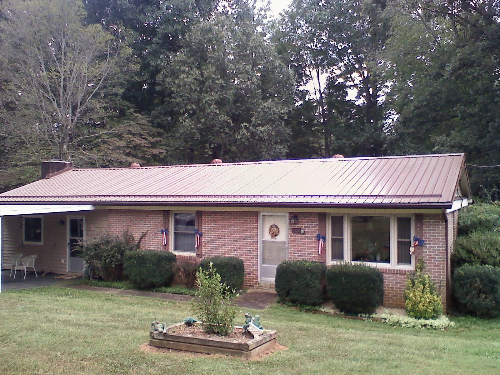 Bronze metal roof on a brick ranch home with a carport in Gold Bar