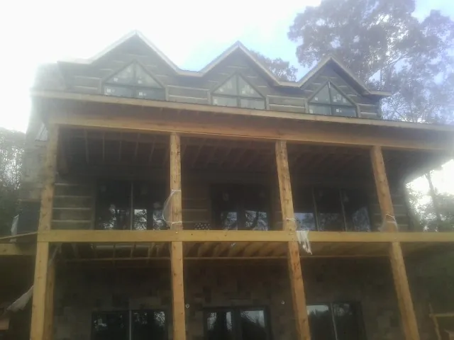 Dormers and porch framing on a large log home under construction — Roof Coating work by our crew in Gold Bar