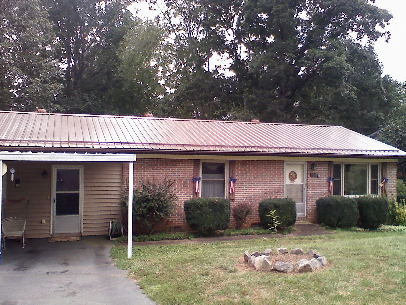 Bronze metal roof and carport on a brick ranch home — Roof Repair work by our crew in Gold Bar
